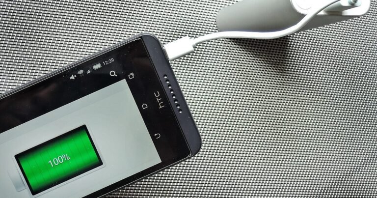 Android phone plugged into a charger showing a full battery reading