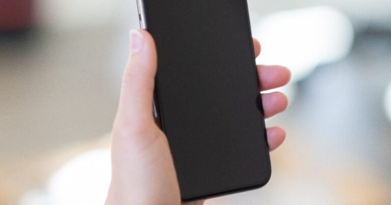 Hand holding a smartphone during an Android privacy settings checkup