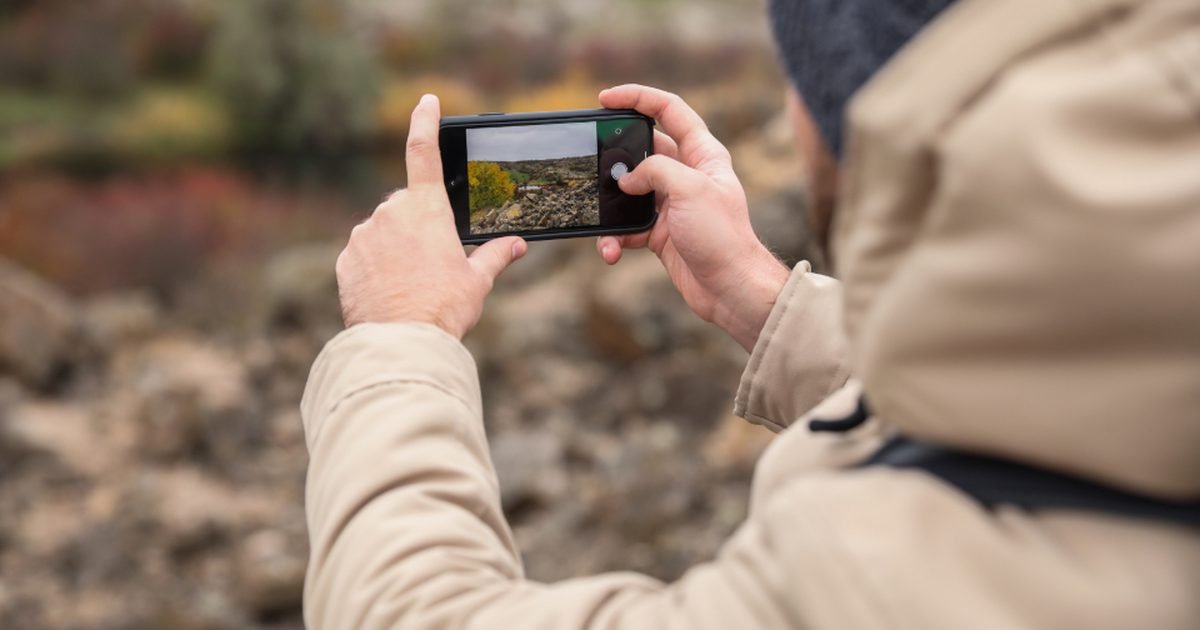 Person using a smartphone outdoors while checking location privacy settings