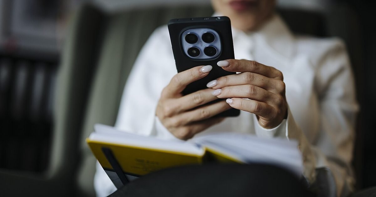 Person holding a smartphone while reviewing call settings
