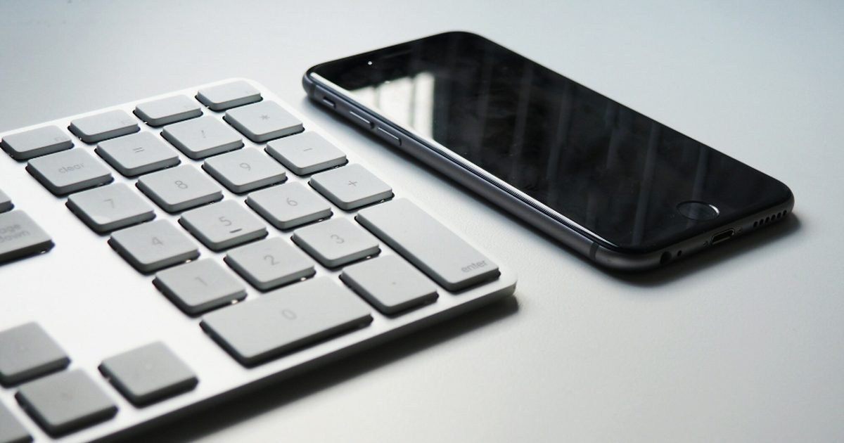 Smartphone beside a keyboard during a phone settings review
