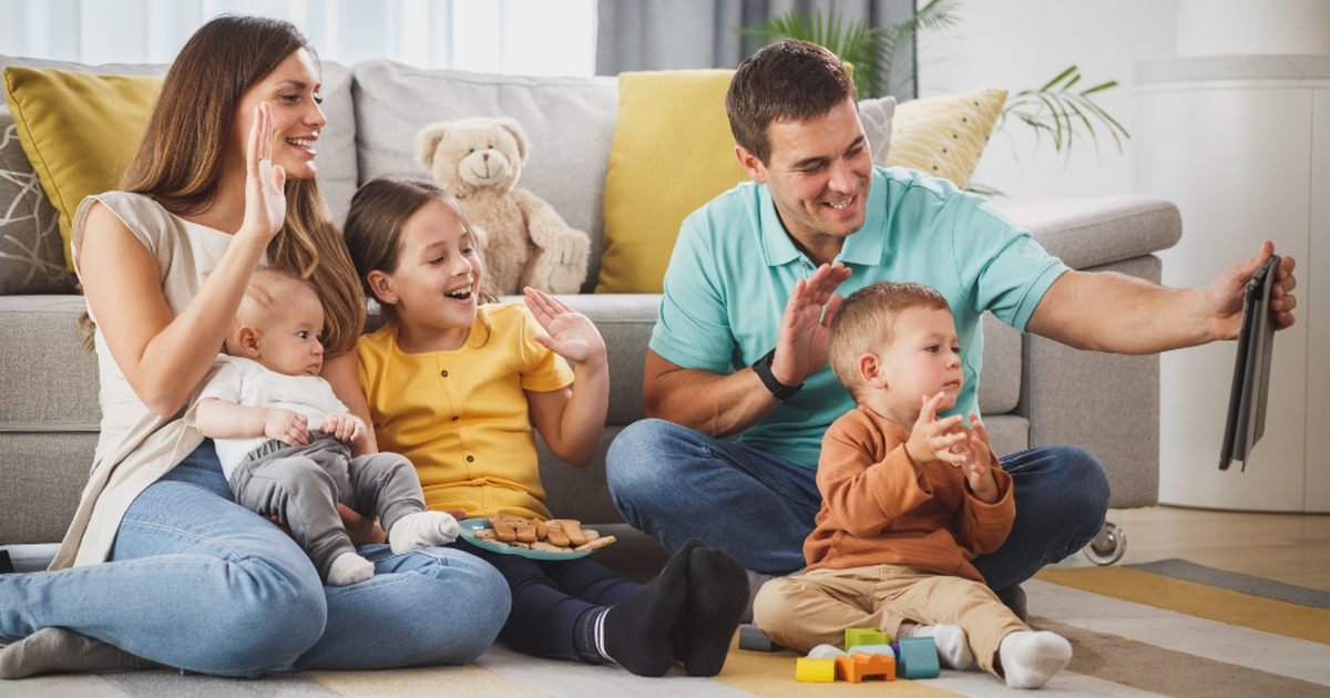 Family sitting together and using a tablet for casual games and video entertainment