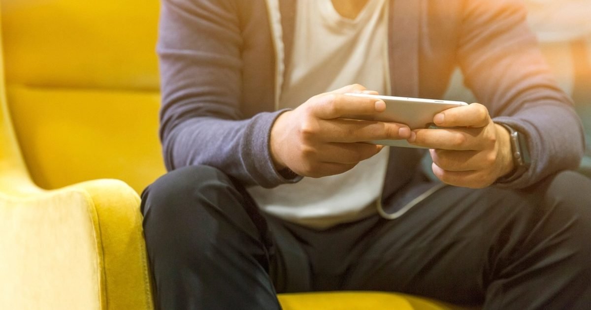 Person using a smartphone while checking app and battery settings