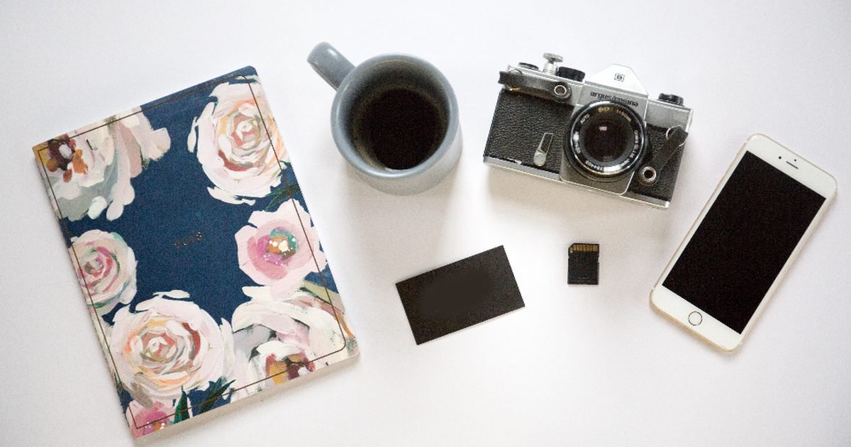 Smartphone, camera and memory card on a desk for photo backup checks